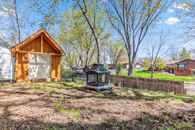 fenced backyard featuring a storage shed and an outdoor structure