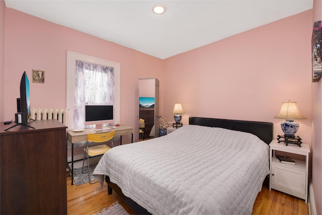 1828 Clinton Ave Unit 3, Minneapolis, MN 55404 - bedroom with radiator heating unit and light wood-style flooring