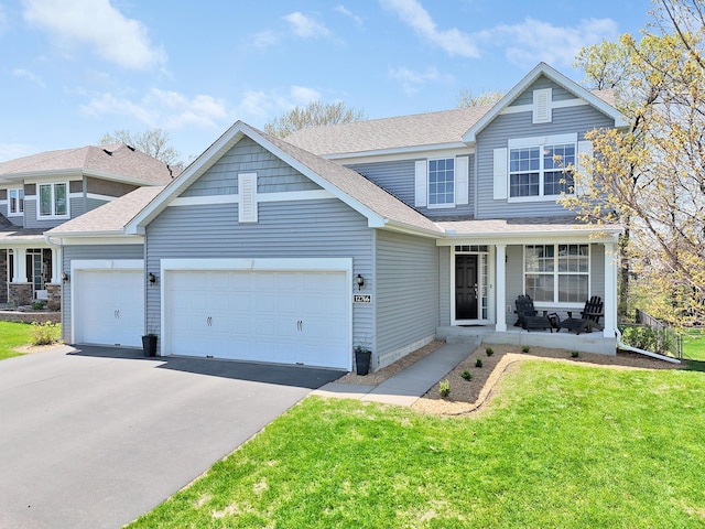 view of front of property with a garage, driveway, a porch, a front yard, and roof with shingles