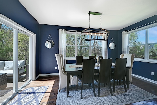 dining room with a chandelier, wood finished floors, and baseboards