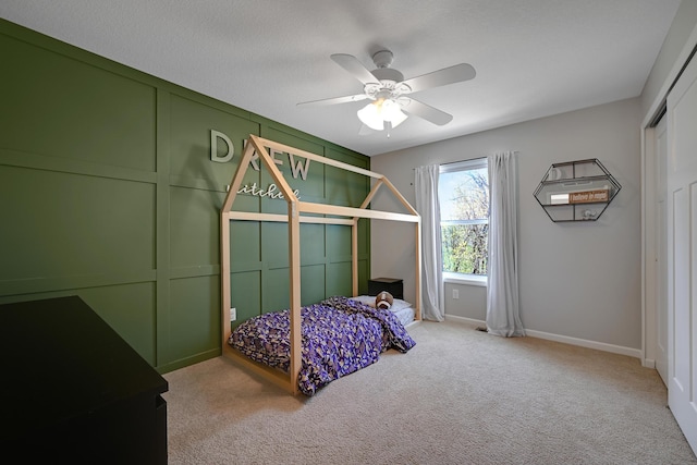 carpeted bedroom with baseboards, a ceiling fan, and a closet