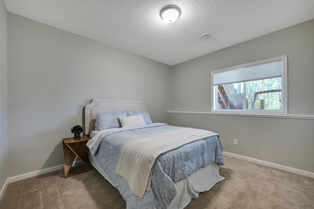 bedroom with carpet flooring, a textured ceiling, and baseboards