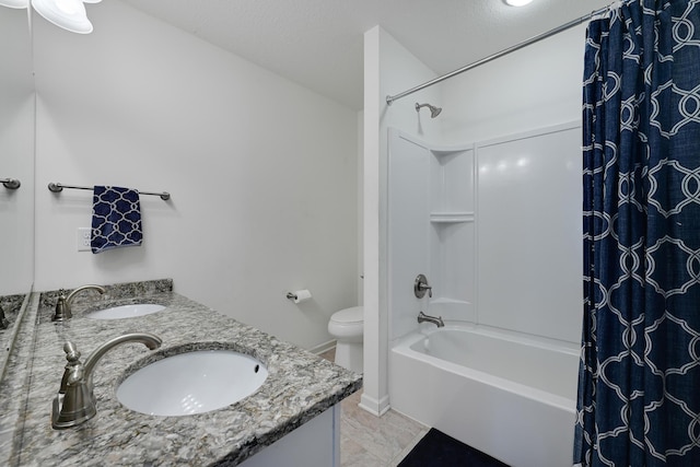 bathroom featuring shower / bath combo with shower curtain, double vanity, toilet, and baseboards