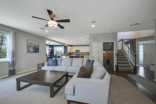 living area with plenty of natural light, ceiling fan, stairs, recessed lighting, and baseboards