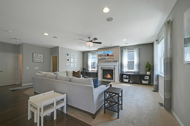 living room with baseboards, a premium fireplace, recessed lighting, and a ceiling fan