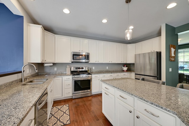 kitchen with stainless steel appliances, a sink, dark wood finished floors, white cabinetry, and recessed lighting