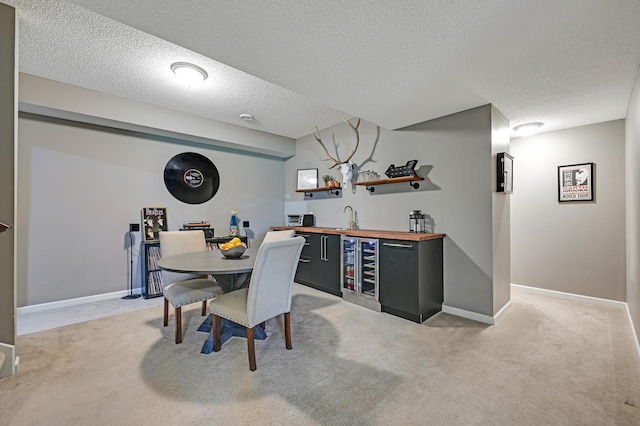 12766 Legacy Creek Pkwy NE, Blaine, MN 55449 - dining area featuring wet bar, light colored carpet, a textured ceiling, beverage cooler, and baseboards