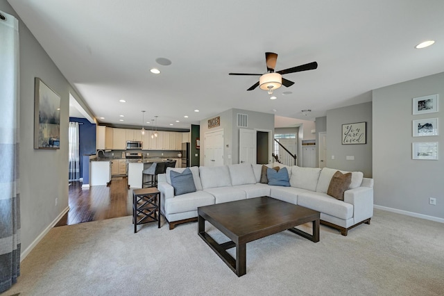 12766 Legacy Creek Pkwy NE, Blaine, MN 55449 - carpeted living room with baseboards, ceiling fan, recessed lighting, stairs, and a sink