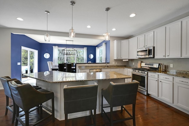 12766 Legacy Creek Pkwy NE, Blaine, MN 55449 - kitchen featuring stainless steel appliances, a breakfast bar area, recessed lighting, dark wood-style flooring, and white cabinetry