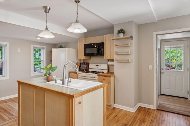 kitchen with white appliances, baseboards, light brown cabinetry, and a sink