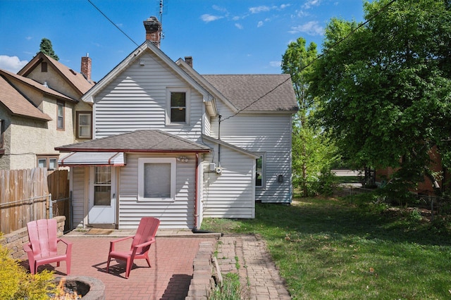 rear view of property with a patio, a fire pit, and roof with shingles