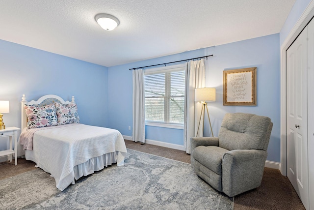 carpeted bedroom featuring baseboards, a closet, and a textured ceiling