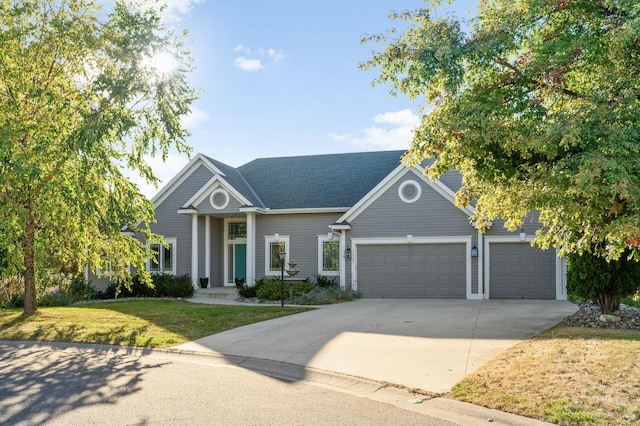 view of front of home featuring a front yard, roof with shingles, a garage, and driveway