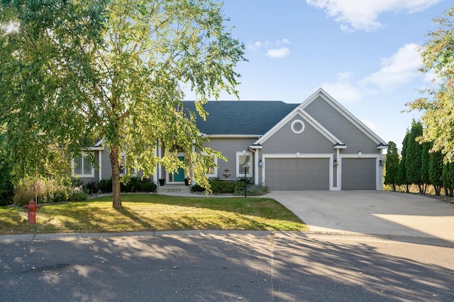 view of front of property with an attached garage, concrete driveway, and a front lawn