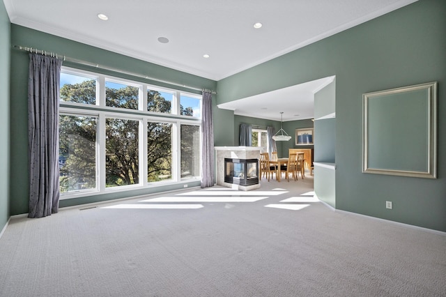 carpeted living area featuring a high end fireplace, ornamental molding, visible vents, recessed lighting, and baseboards