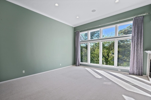 carpeted spare room featuring crown molding, baseboards, and recessed lighting