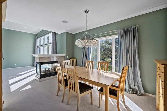 dining area featuring a chandelier, ornamental molding, carpet, and plenty of natural light