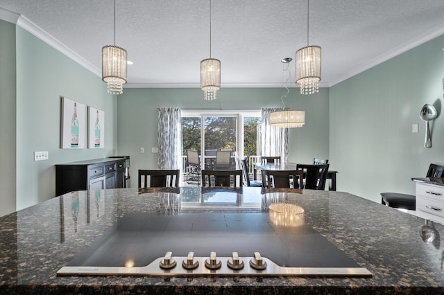 kitchen with ornamental molding, a textured ceiling, and hanging light fixtures