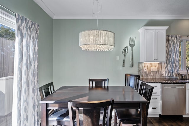 dining room with a chandelier, ornamental molding, and dark wood-style floors