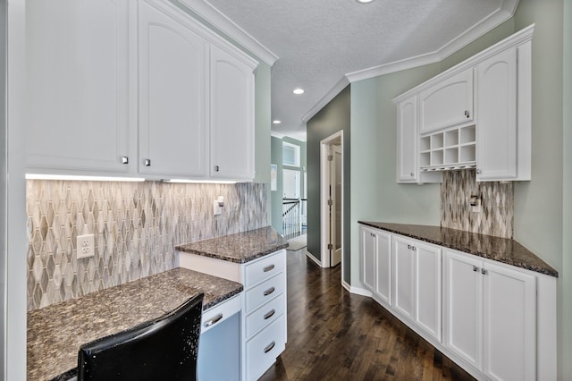 kitchen with backsplash, white cabinetry, and dark stone countertops