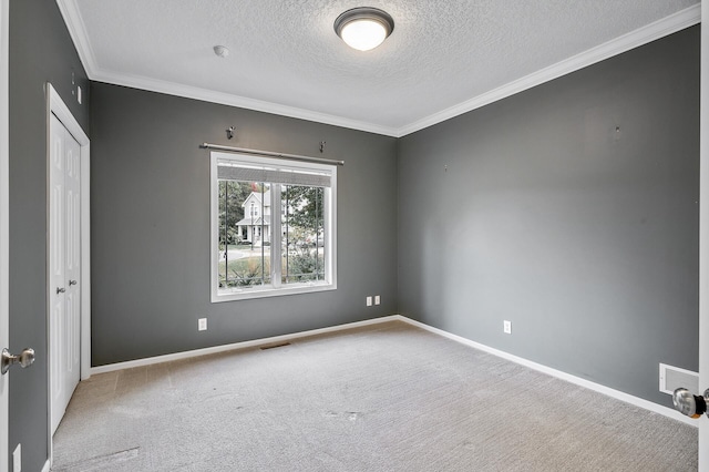 carpeted empty room with crown molding, visible vents, and a textured ceiling
