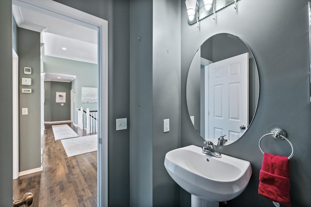 bathroom with wood finished floors, baseboards, and a sink