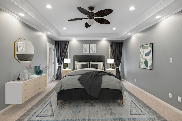 bedroom with a tray ceiling, recessed lighting, baseboards, ornamental molding, and light colored carpet