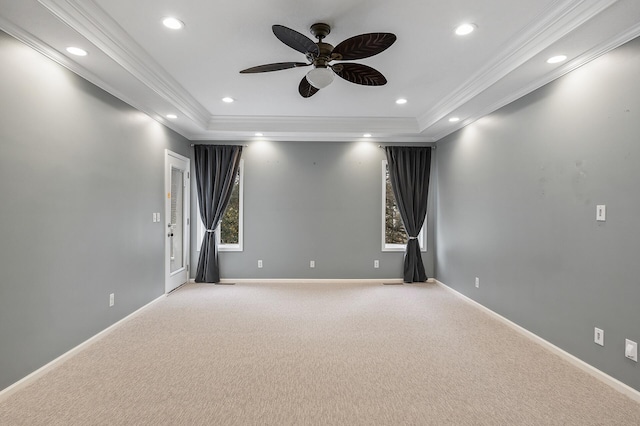 unfurnished room featuring a raised ceiling, recessed lighting, crown molding, and light colored carpet