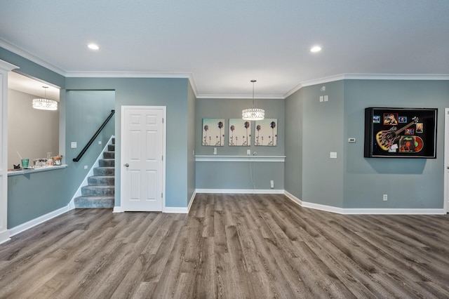 unfurnished living room with stairway, wood finished floors, baseboards, and ornamental molding
