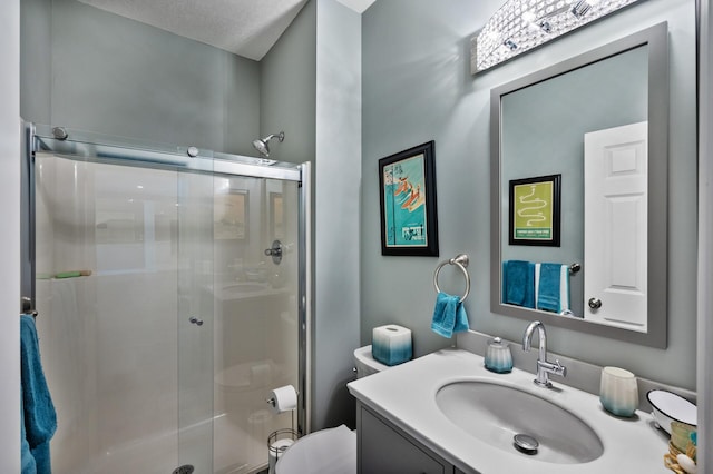 bathroom featuring a stall shower, vanity, and toilet