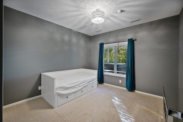 bedroom featuring baseboards, carpet flooring, and a textured ceiling