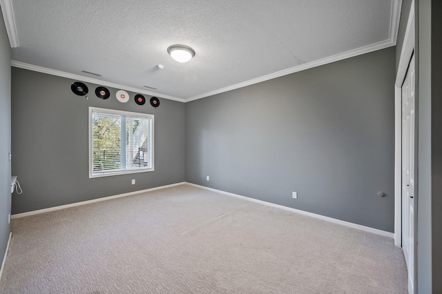 unfurnished room featuring baseboards, carpet floors, ornamental molding, and a textured ceiling