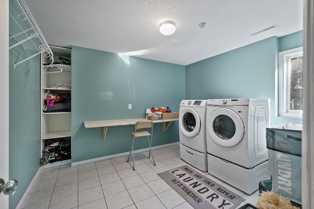 laundry area with light tile patterned floors, laundry area, washer and clothes dryer, visible vents, and baseboards