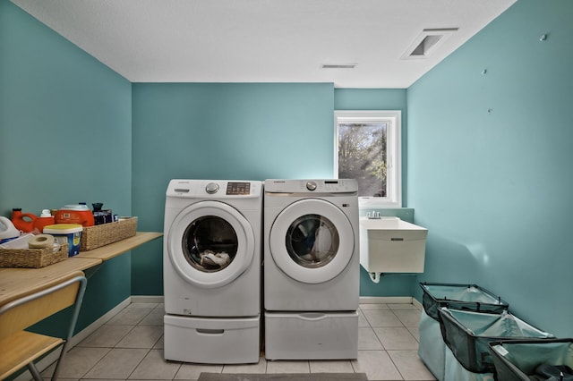 clothes washing area with laundry area, tile patterned floors, visible vents, and washer and dryer