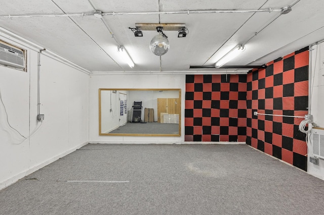 basement featuring baseboards, a garage, and carpet floors