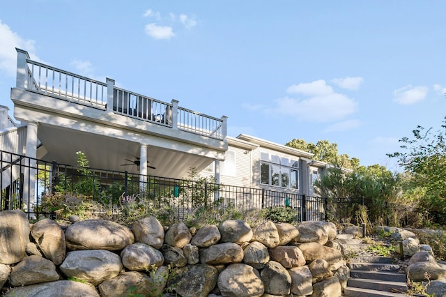 exterior space featuring fence, ceiling fan, and a balcony