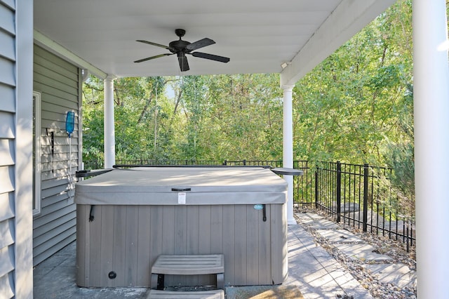 view of patio with a hot tub, fence, and a ceiling fan