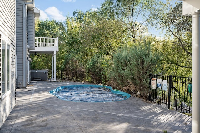view of swimming pool featuring a hot tub, fence, a covered pool, and a patio