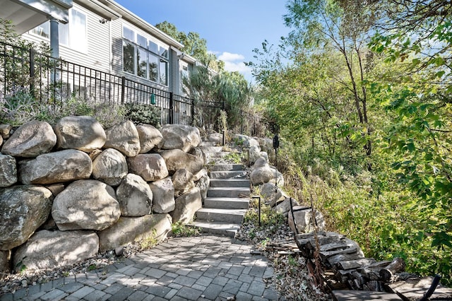 view of property's community with a patio area, stairway, and fence