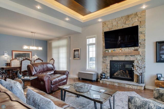 living room featuring baseboards, a fireplace, and wood finished floors