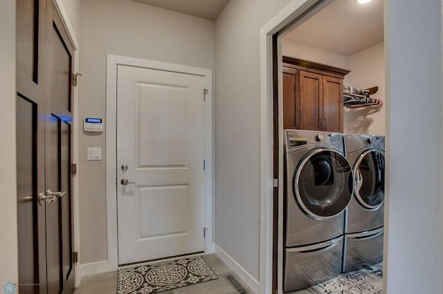 clothes washing area with separate washer and dryer, cabinet space, baseboards, and visible vents