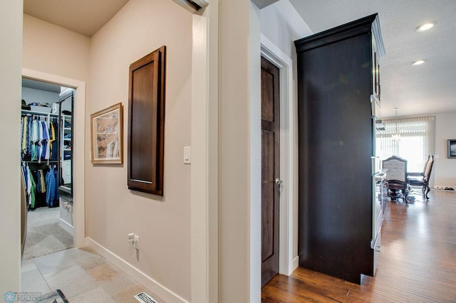 hall featuring visible vents, baseboards, and recessed lighting