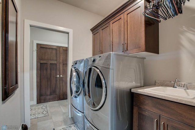 washroom with washer and clothes dryer, a sink, and cabinet space