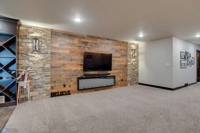 unfurnished living room featuring baseboards, a fireplace, recessed lighting, and carpet