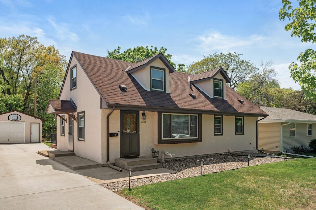 420 Ruby Dr W, Saint Paul, MN 55118 - view of front of house with an outbuilding, stucco siding, concrete driveway, a garage, and a front yard