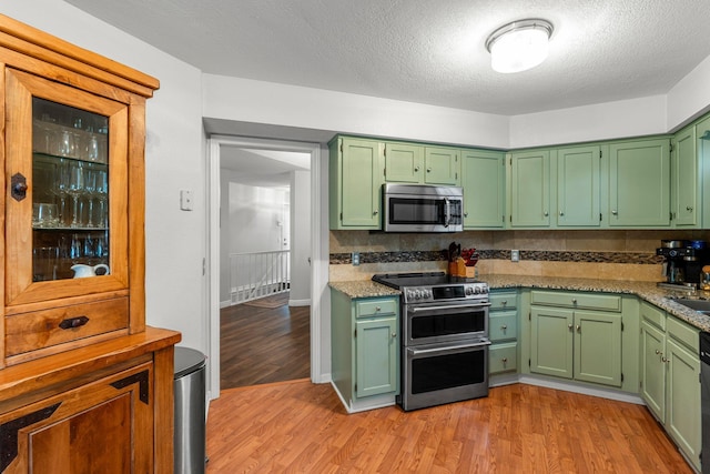 95 Olympic Cir, Chanhassen, MN 55317 - kitchen featuring stainless steel appliances, light wood-style flooring, a textured ceiling, and green cabinetry
