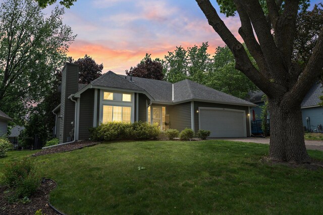 95 Olympic Cir, Chanhassen, MN 55317 - view of front facade featuring an attached garage, a chimney, a front lawn, and driveway