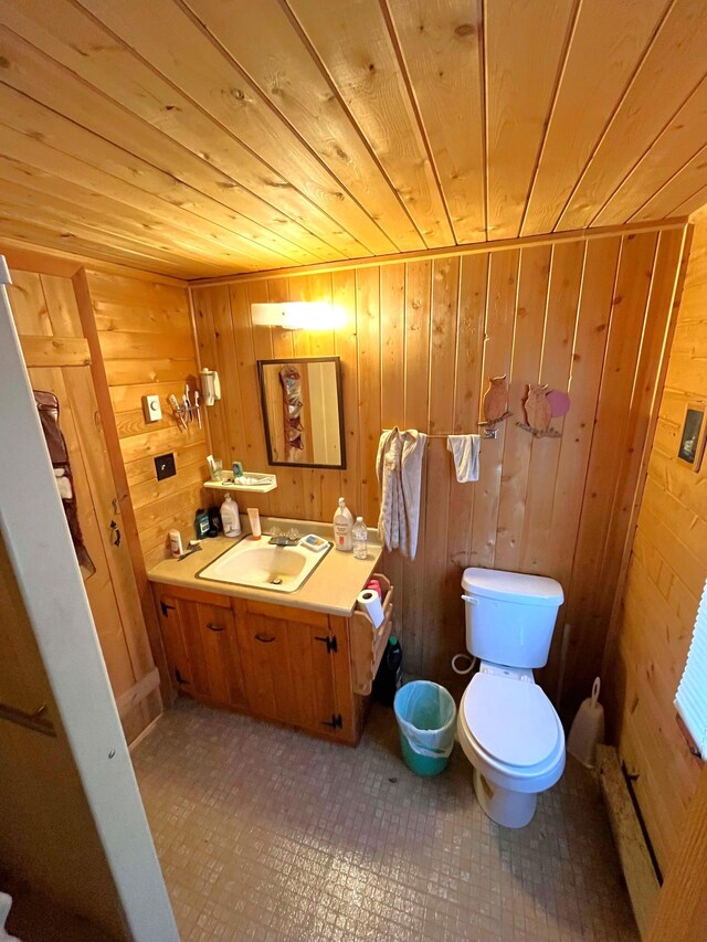 17353 Pine Dr NW, Angle Inlet, MN 56711 - half bathroom with wood ceiling, wood walls, toilet, and vanity