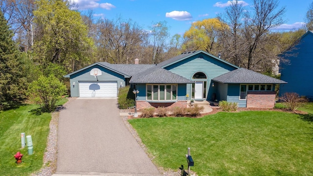 ranch-style home with driveway, brick siding, a garage, a front yard, and roof with shingles