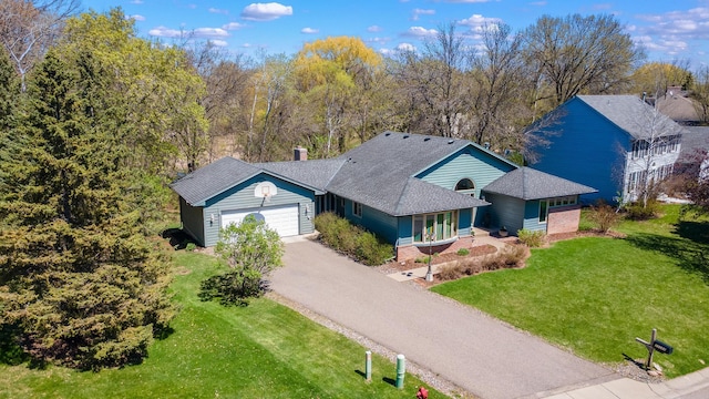 view of front of home featuring an attached garage, a front lawn, and aphalt driveway